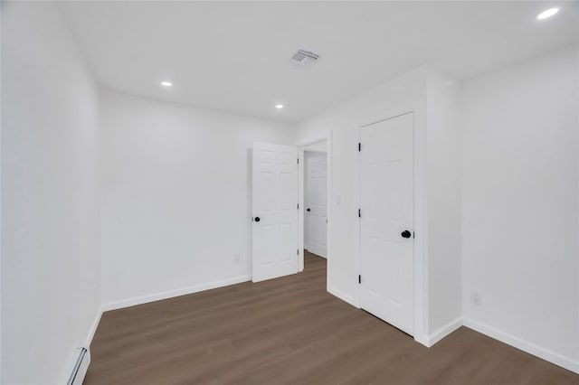 unfurnished room featuring recessed lighting, wood finished floors, visible vents, and baseboards