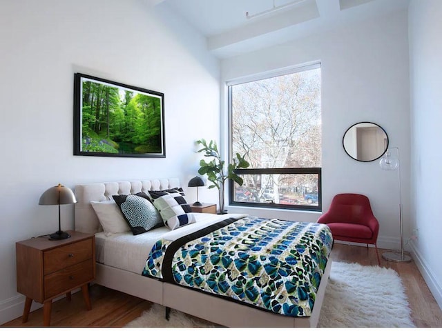 bedroom with baseboards and wood finished floors