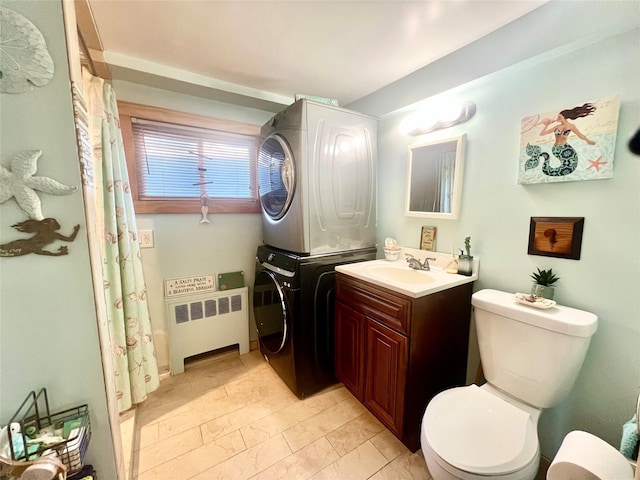 bathroom featuring toilet, stacked washer and dryer, a shower with shower curtain, vanity, and radiator heating unit