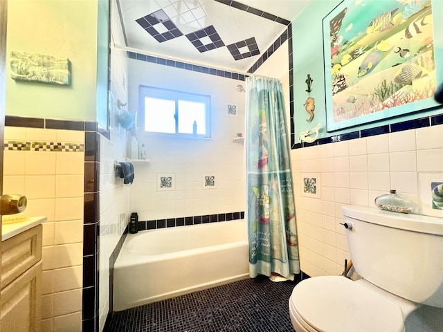 full bathroom with shower / tub combo with curtain, tile walls, toilet, wainscoting, and tile patterned flooring