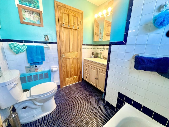 bathroom featuring toilet, vanity, tile walls, tile patterned floors, and radiator