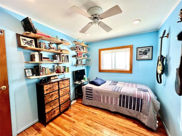 bedroom with baseboards, ornamental molding, ceiling fan, and wood finished floors