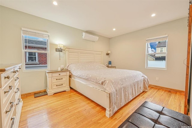 bedroom with light wood finished floors, a wall mounted air conditioner, recessed lighting, and baseboards