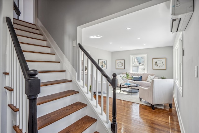 stairway featuring recessed lighting, a wall mounted air conditioner, baseboards, and wood finished floors