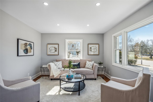 living area with recessed lighting, plenty of natural light, and baseboards