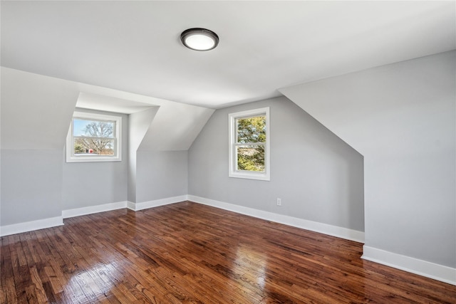 additional living space with a healthy amount of sunlight, hardwood / wood-style flooring, and baseboards