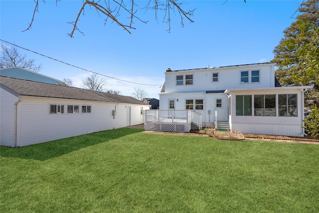 rear view of property with a sunroom, a yard, and a deck