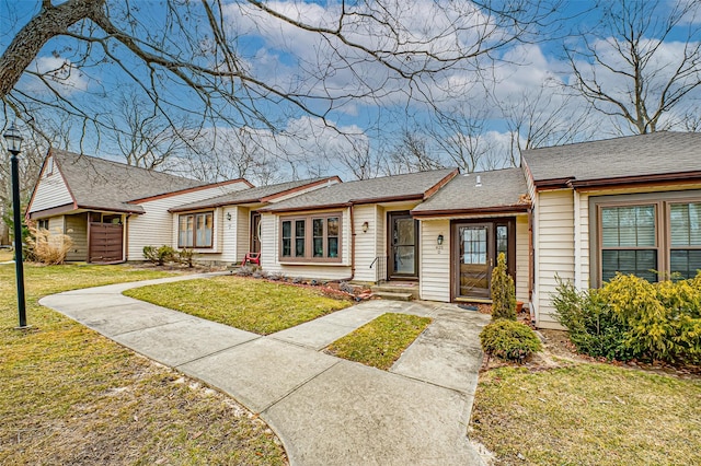 single story home with a shingled roof and a front yard