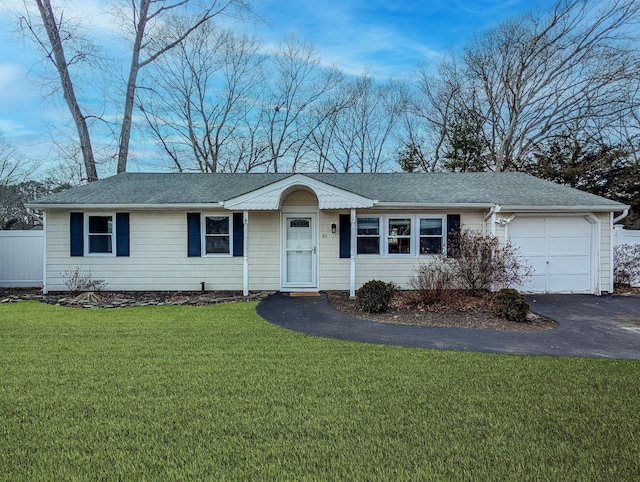 single story home featuring driveway, roof with shingles, an attached garage, and a front yard