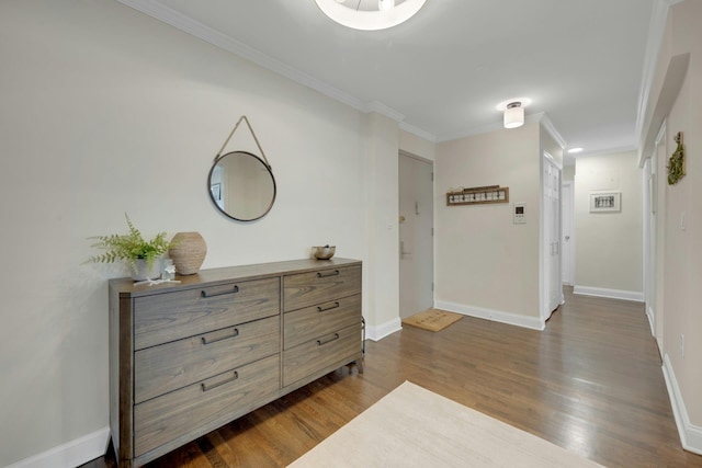 hallway featuring ornamental molding, dark wood finished floors, and baseboards