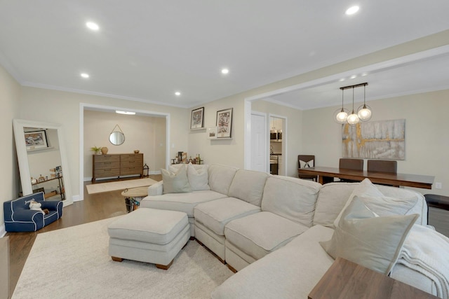 living room featuring crown molding, baseboards, wood finished floors, and recessed lighting