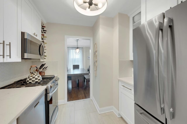 kitchen featuring white cabinets, appliances with stainless steel finishes, light countertops, and backsplash