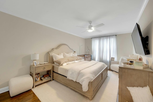 bedroom with ceiling fan, baseboards, wood finished floors, and crown molding