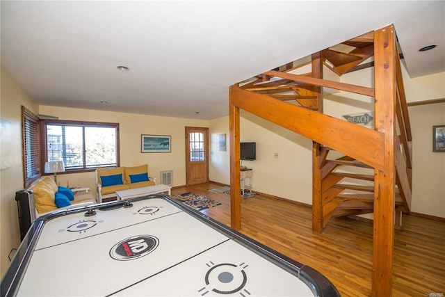 recreation room featuring plenty of natural light, visible vents, and wood finished floors