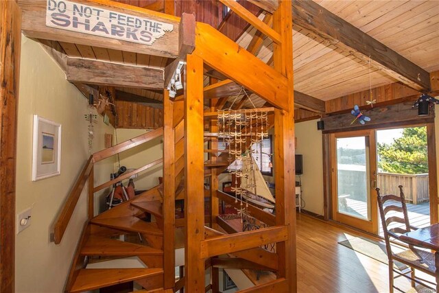 stairway with beam ceiling, wood ceiling, and wood finished floors