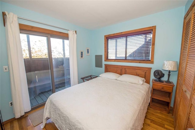 bedroom featuring a closet, wood finished floors, and access to outside