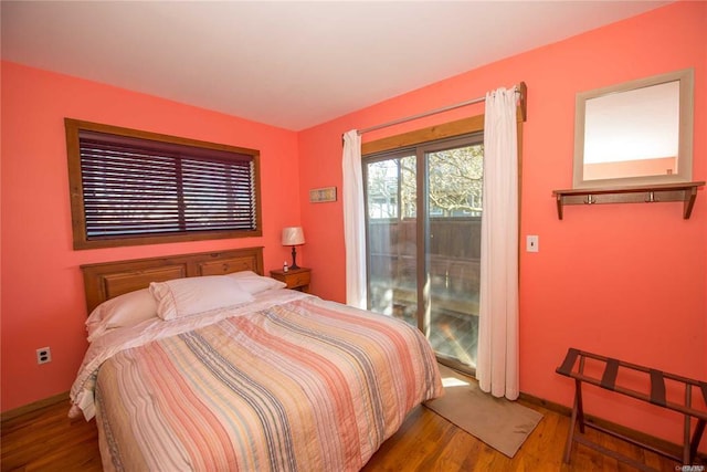 bedroom featuring access to exterior and wood finished floors