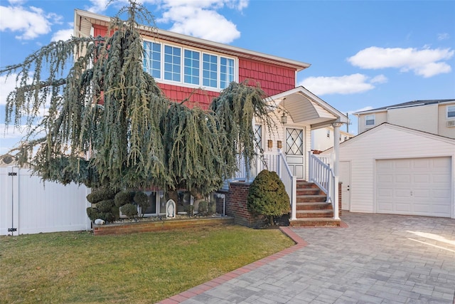 view of front facade with a garage, an outbuilding, decorative driveway, and a front yard