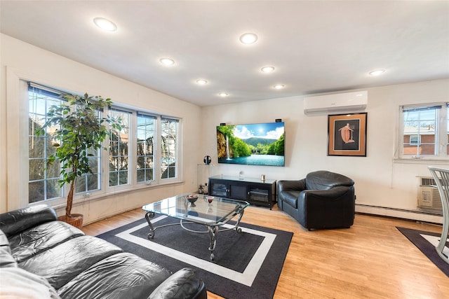 living area featuring light wood-type flooring, a wealth of natural light, a baseboard radiator, and an AC wall unit