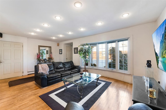 living area with a baseboard heating unit, wood finished floors, and recessed lighting