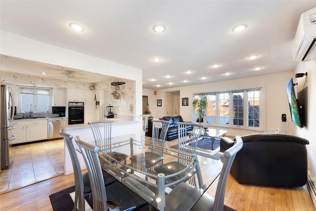 dining room featuring light wood-style floors, recessed lighting, and a wall mounted air conditioner