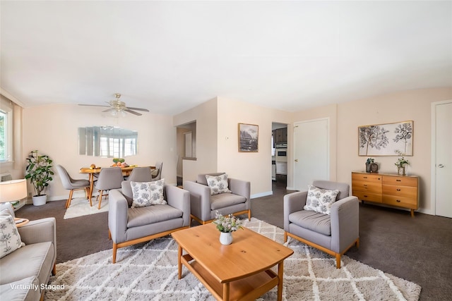 carpeted living room featuring a ceiling fan and baseboards