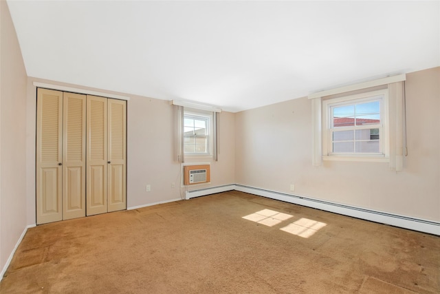 unfurnished bedroom featuring a closet, carpet flooring, a wall mounted AC, and baseboards