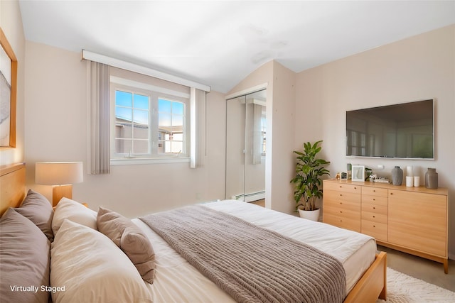 bedroom featuring lofted ceiling, a baseboard heating unit, and a closet