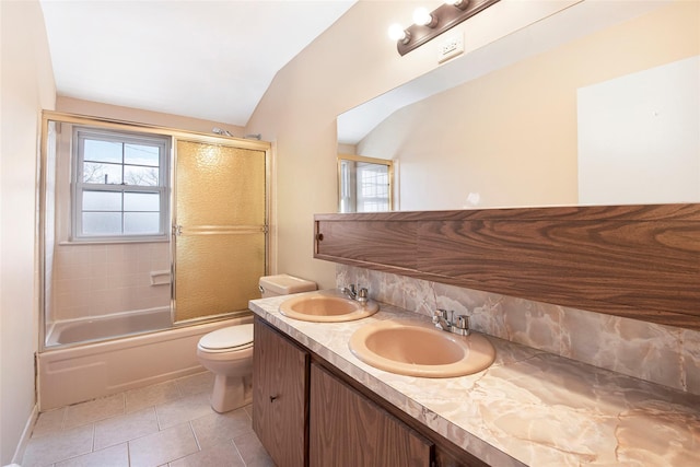 full bath with toilet, tile patterned flooring, double vanity, and a sink