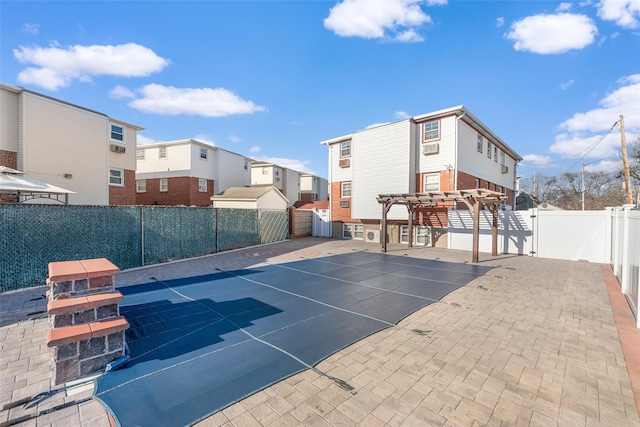 view of basketball court featuring a residential view, a fenced backyard, and a pergola