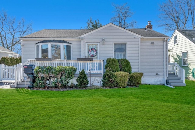 view of front facade with roof with shingles, fence, a chimney, and a front lawn