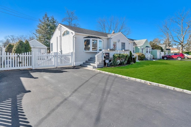 view of front of house with a front lawn, fence, and a gate