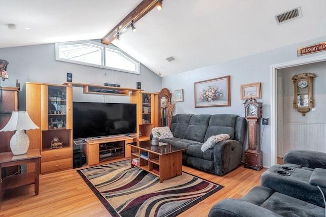 living area featuring lofted ceiling with beams, wood finished floors, and visible vents