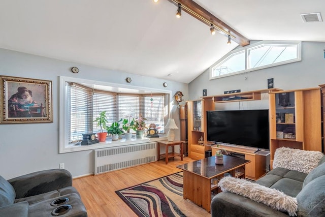 living room with visible vents, radiator heating unit, wood finished floors, rail lighting, and vaulted ceiling