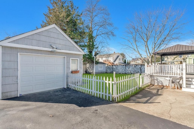 detached garage with aphalt driveway and fence