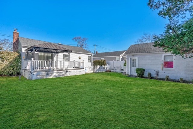 back of house with fence, a gazebo, a lawn, roof with shingles, and a chimney