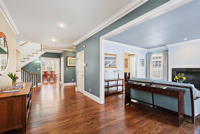 foyer featuring baseboards, dark wood-style floors, stairway, crown molding, and a fireplace