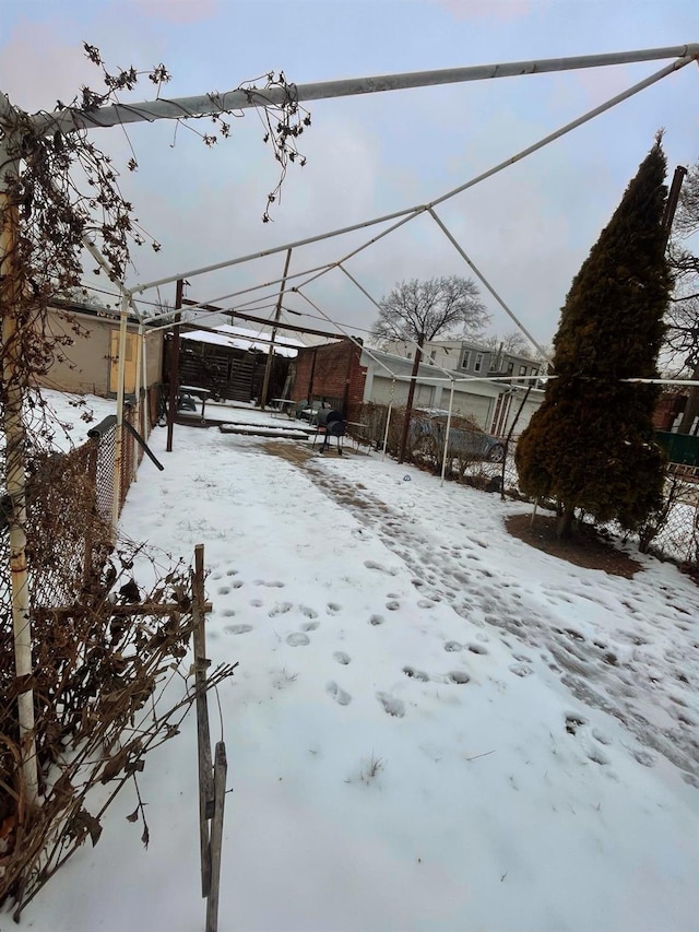 yard covered in snow featuring fence