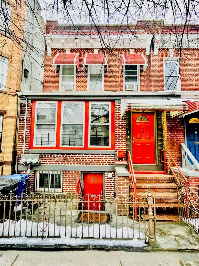 view of property featuring a fenced front yard and brick siding