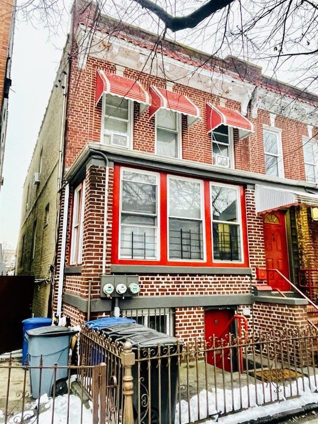 view of front of property with a fenced front yard and brick siding