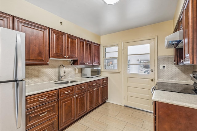 kitchen with extractor fan, a sink, light countertops, stainless steel electric range, and freestanding refrigerator