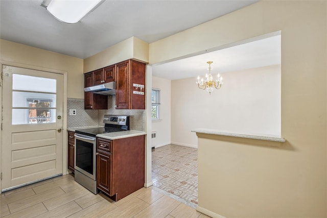 kitchen with under cabinet range hood, wood finish floors, light countertops, backsplash, and stainless steel electric range oven