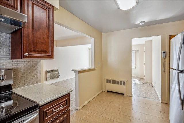 kitchen with range hood, stainless steel appliances, tasteful backsplash, radiator, and a wall mounted air conditioner