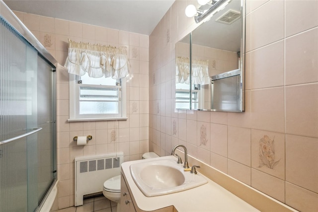 full bathroom featuring visible vents, radiator, a shower with door, toilet, and tile walls