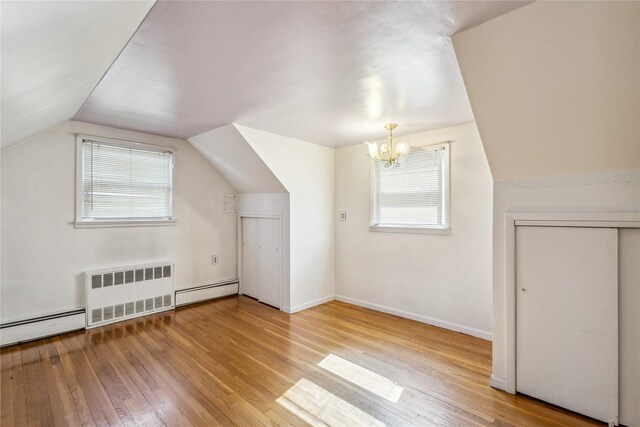 bonus room featuring radiator, hardwood / wood-style flooring, a baseboard heating unit, and vaulted ceiling