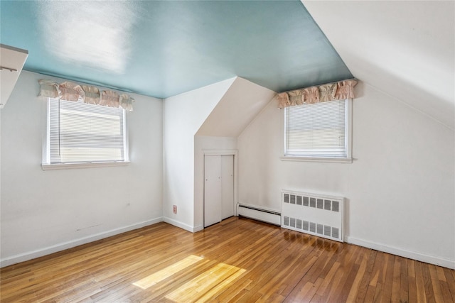 bonus room featuring baseboards, lofted ceiling, radiator heating unit, wood-type flooring, and baseboard heating