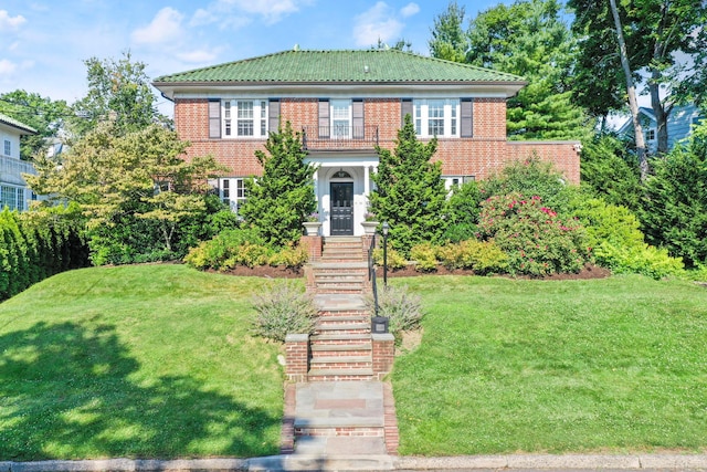 view of front facade with brick siding and a front yard