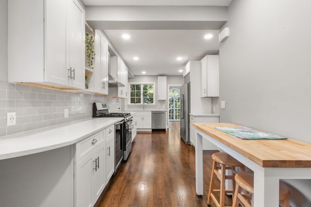 kitchen with stainless steel appliances, dark wood-type flooring, and white cabinetry