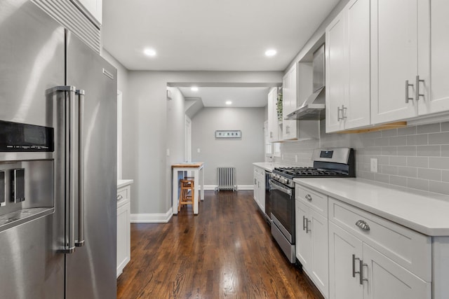 kitchen with white cabinets, radiator heating unit, appliances with stainless steel finishes, and light countertops