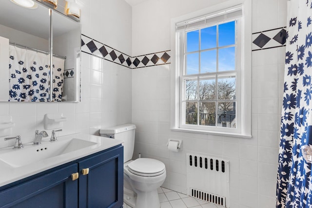 full bath featuring radiator heating unit, vanity, tile walls, and tile patterned floors